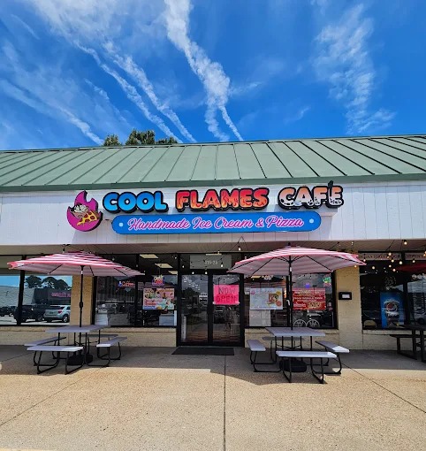 Daytime exterior view of Cool Flames Cafe showing shop signage, outdoor seating, and store entrance.