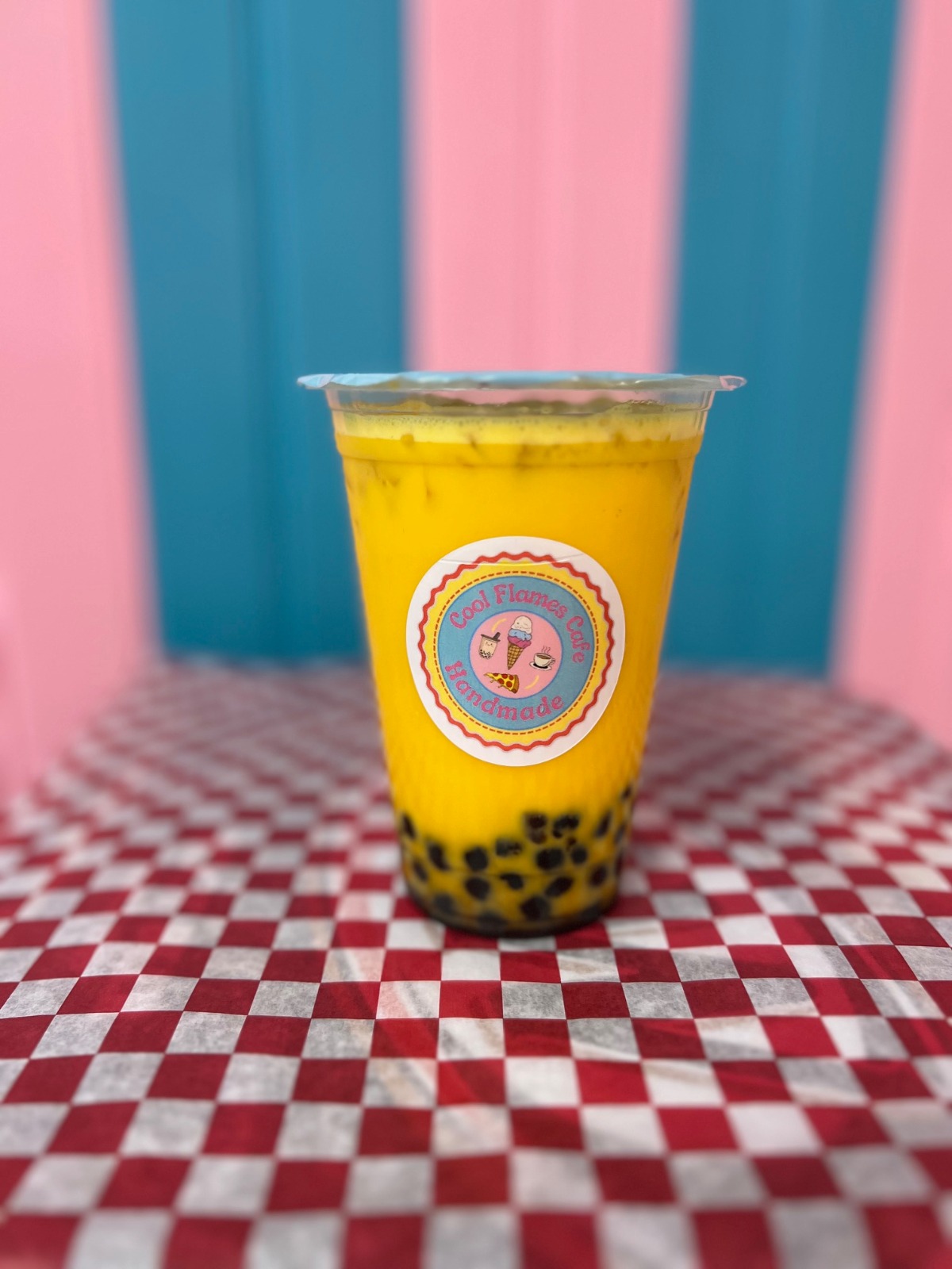 Iced mango bubble tea with black tapioca pearls served at Cool Flames Cafe.
